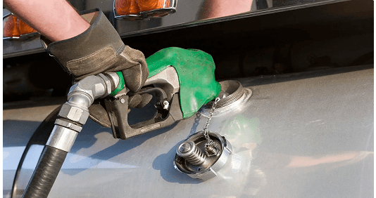 Fuel nozzle filling a vehicle's gas tank.